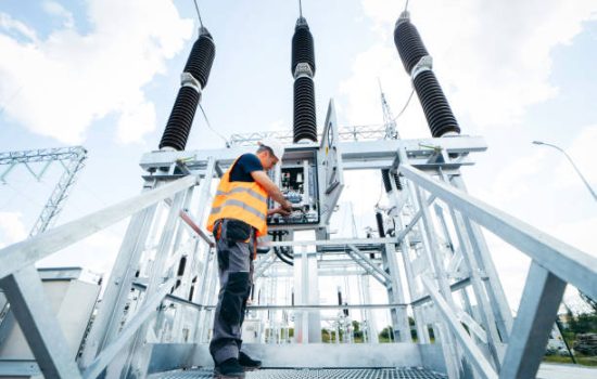 Adult electrical engineer inspect the electrical systems at the equipment control cabinet. Installation of modern electrical station
